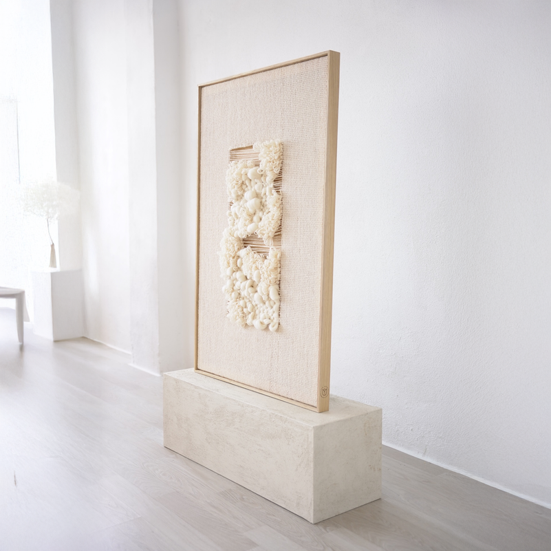 A modern framed tapestry displayed on a wooden stand, featuring a minimalist design with subtle patterns, housed in a natural oak frame.